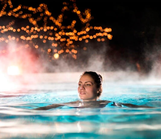 mujer nadando en piscina con calentamiento mediante bomba de calor con tecnología inverter