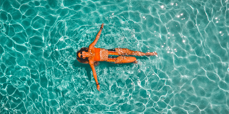 mujer en piscina calentada con paneles solares