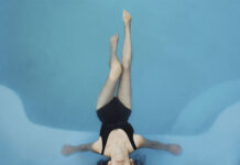 mujer en el interior de una piscina con agua calentada a través del funcionamiento de una bomba de calor