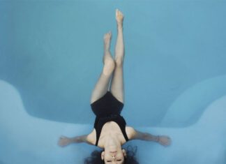 mujer en el interior de una piscina con agua calentada a través del funcionamiento de una bomba de calor